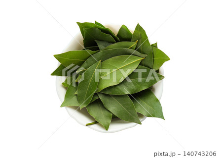 Fresh bay leaves are neatly placed in a bowl for culinary preparation, PNG 140743206