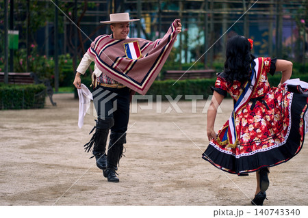 Portrait of a smiling young couple dressed as Chilean huasos, joyfully dancing Portrait of a smiling young couple dressed as Chilean huasos, joyfully dancing 140743340