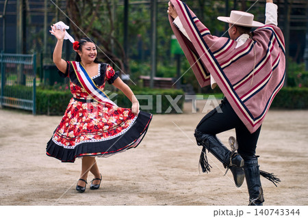 Portrait of a smiling young couple dressed as Chilean huasos, joyfully dancing Portrait of a smiling young couple dressed as Chilean huasos, joyfully dancing 140743344