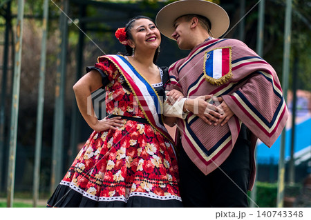 Portrait of a smiling young couple, dressed as Chilean huasos, looking at each other 140743348