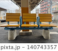 駅のホームに設置された黄色の木製ベンチ 140743357