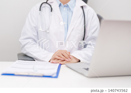 Professional doctor wearing lab coat and stethoscope using laptop computer and taking report notes on notebook at desk in hospital clinic office, medical technology and healthcare concept Professional doctor wearing lab coat and stethoscope using laptop computer and taking report notes on notebook at desk in hospital clinic office, medical technology and healthcare concept 140743562
