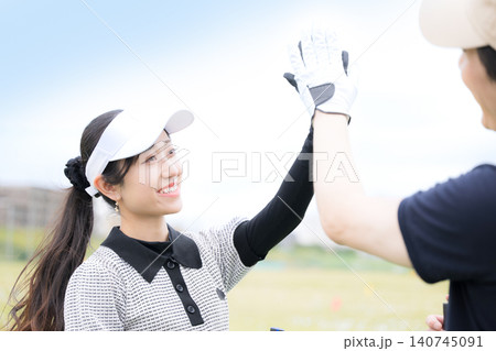 ゴルフが楽しい男女がハイタッチで喜ぶ 成功とスポーツの達成感を表現したシーン ゴルフが楽しい男女がハイタッチで喜ぶ 成功とスポーツの達成感を表現したシーン 140745091