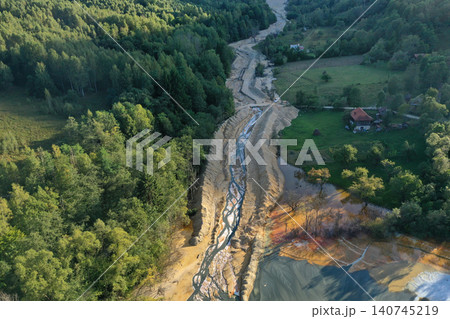 Aerial view of flowing toxic gold mining residual metal-rich water contaminates ecosystems. Rosia Montana, Romania Aerial view of flowing toxic gold mining residual metal-rich water contaminates ecosystems. Rosia Montana, Romania 140745219