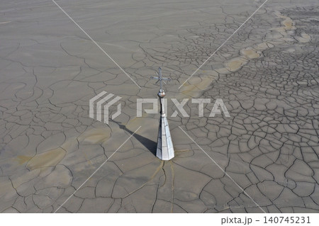 Aerial view of a sinking church in a decanting lake, tower with cross raising over mud Aerial view of a sinking church in a decanting lake, tower with cross raising over mud 140745231