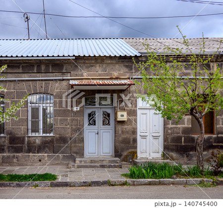 Weathered stone building with ornate doors and rusty roof Weathered stone building with ornate doors and rusty roof 140745400