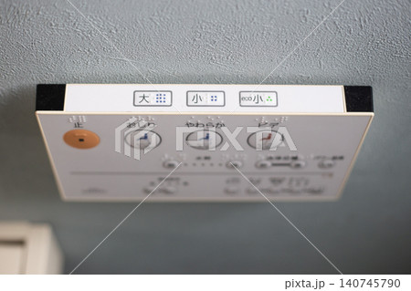 水色の壁に設置されたウォシュレットのリモコン 140745790