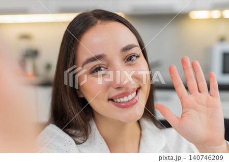 Young woman waves to phone pov greets with smile shares update friendly voice close view direct talk Young woman waves to phone pov greets with smile shares update friendly voice close view direct talk 140746209