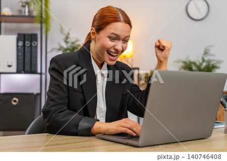 Young businesswoman celebrates project approval on laptop breathes loudly shouting victory success Young businesswoman celebrates project approval on laptop breathes loudly shouting victory success 140746408