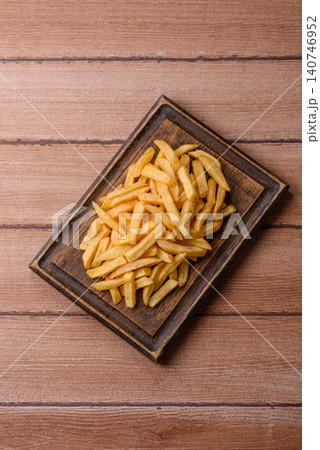 Golden French fries fried with salt and spices, unhealthy takeaway food. French fries Golden French fries fried with salt and spices, unhealthy takeaway food. French fries 140746952