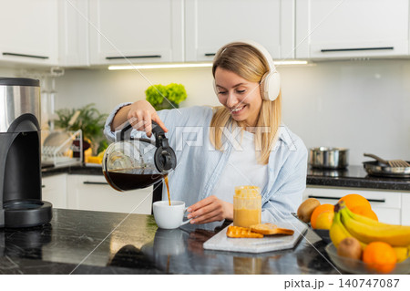 Young woman pouring morning coffee in home kitchen with toast and peanut butter breakfast aroma joy Young woman pouring morning coffee in home kitchen with toast and peanut butter breakfast aroma joy 140747087