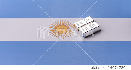 A silver bar, white metal against a backdrop of Argentine money, as a concept for the sales market A silver bar, white metal against a backdrop of Argentine money, as a concept for the sales market 140747204