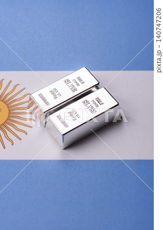 A silver bar, white metal against a backdrop of Argentine money, as a concept for the sales market A silver bar, white metal against a backdrop of Argentine money, as a concept for the sales market 140747206