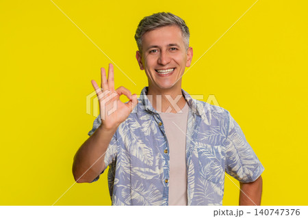 Adult man showing OK hand gesture with confident positive expression expressing support and approval 140747376