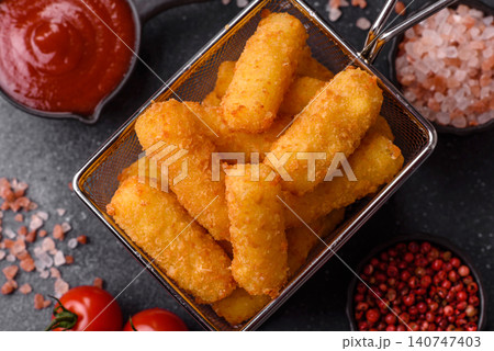 Mozzarella cheese sticks, breaded and fried with salt and tomato sauce, for takeaway. Cheese sticks Mozzarella cheese sticks, breaded and fried with salt and tomato sauce, for takeaway. Cheese sticks 140747403