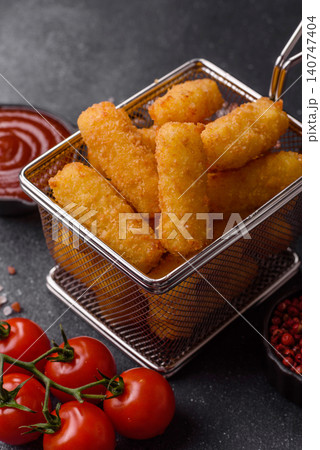 Mozzarella cheese sticks, breaded and fried with salt and tomato sauce, for takeaway. Cheese sticks Mozzarella cheese sticks, breaded and fried with salt and tomato sauce, for takeaway. Cheese sticks 140747404