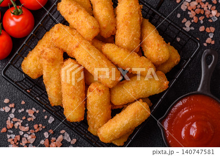 Mozzarella cheese sticks, breaded and fried with salt and tomato sauce, for takeaway. Cheese sticks Mozzarella cheese sticks, breaded and fried with salt and tomato sauce, for takeaway. Cheese sticks 140747581