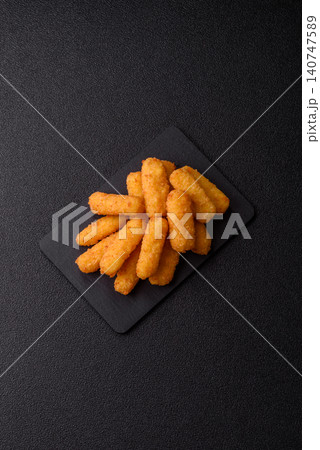 Mozzarella cheese sticks, breaded and fried with salt and tomato sauce, for takeaway. Cheese sticks Mozzarella cheese sticks, breaded and fried with salt and tomato sauce, for takeaway. Cheese sticks 140747589