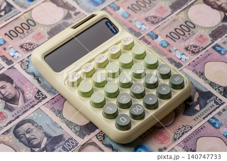 A calculator with Japanese Yen banknotes. A calculator with Japanese currency A calculator with Japanese Yen banknotes. A calculator with Japanese currency 140747733