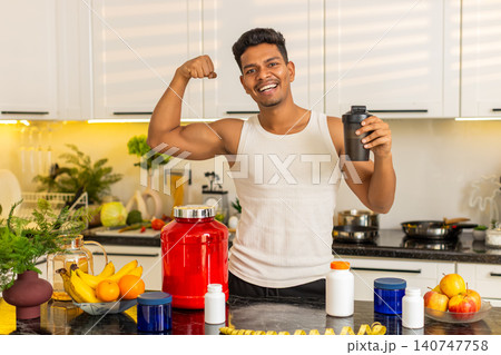 Indian man presenting sports supplements and protein shaker for workout nutrition and diet at home Indian man presenting sports supplements and protein shaker for workout nutrition and diet at home 140747758
