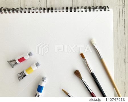 お絵かき・アート・スケッチブック・画用紙の背景素材と絵の具チューブ・水彩筆、木目テーブル お絵かき・アート・スケッチブック・画用紙の背景素材と絵の具チューブ・水彩筆、木目テーブル 140747918