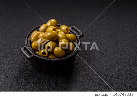 Whole green olives without pits in a bowl as an ingredient for cooking at home. Green olives Whole green olives without pits in a bowl as an ingredient for cooking at home. Green olives 140748338