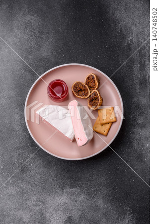 Pink Brie or Camembert cheese with honey, jam, figs, and crackers. Brie cheese Pink Brie or Camembert cheese with honey, jam, figs, and crackers. Brie cheese 140748502