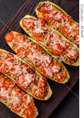 Baked zucchini half with minced meat, tomatoes, cheese, salt, and spices. Zucchini with minced meat Baked zucchini half with minced meat, tomatoes, cheese, salt, and spices. Zucchini with minced meat 140748515