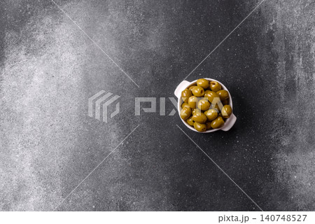 Whole green olives without pits in a bowl as an ingredient for cooking at home. Green olives Whole green olives without pits in a bowl as an ingredient for cooking at home. Green olives 140748527