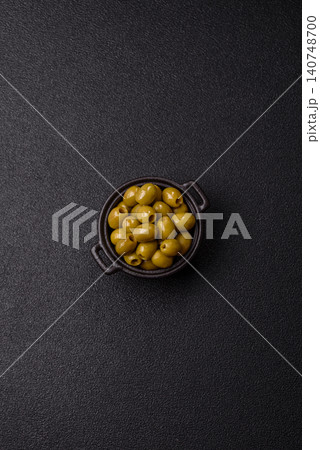 Whole green olives without pits in a bowl as an ingredient for cooking at home. Green olives Whole green olives without pits in a bowl as an ingredient for cooking at home. Green olives 140748700