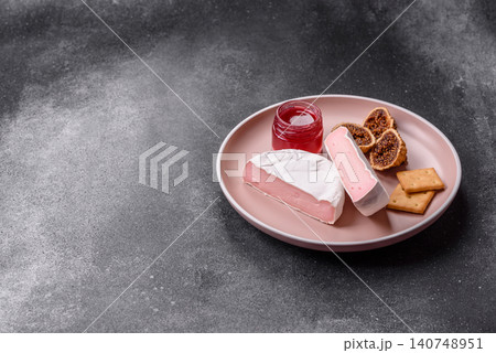 Pink Brie or Camembert cheese with honey, jam, figs, and crackers. Brie cheese Pink Brie or Camembert cheese with honey, jam, figs, and crackers. Brie cheese 140748951