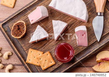 Pink Brie or Camembert cheese with honey, jam, figs, and crackers. Brie cheese Pink Brie or Camembert cheese with honey, jam, figs, and crackers. Brie cheese 140748952