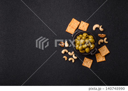 Whole green olives without pits in a bowl as an ingredient for cooking at home. Green olives Whole green olives without pits in a bowl as an ingredient for cooking at home. Green olives 140748990
