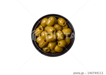 Whole green olives without pits in a bowl as an ingredient for cooking at home. Green olives Whole green olives without pits in a bowl as an ingredient for cooking at home. Green olives 140749111