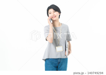 白背景で電話をしながら横を見る笑顔の若い女性 140749294