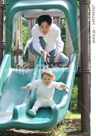 公園ですべり台を楽しむ娘と父親 公園ですべり台を楽しむ娘と父親 140749387