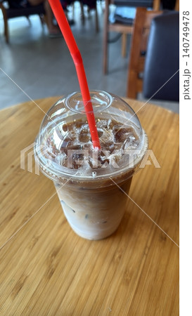 Refreshing Iced Latte Coffee in Takeaway Cup on Wooden Cafe Table Refreshing Iced Latte Coffee in Takeaway Cup on Wooden Cafe Table 140749478