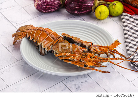 Cooked lobster on white plate with eggplants and limes Cooked lobster on white plate with eggplants and limes 140750167