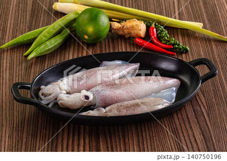 Fresh squid in black pan with lime lemongrass chili and okra on wooden surface 140750196