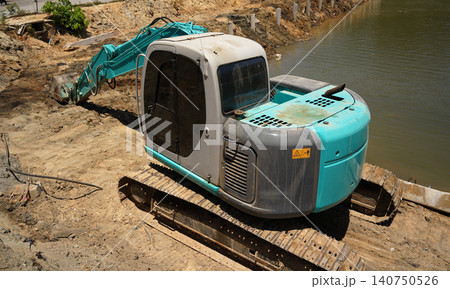 Building process city levee. Excavator dredging pond bank Building process city levee. Excavator dredging pond bank 140750526