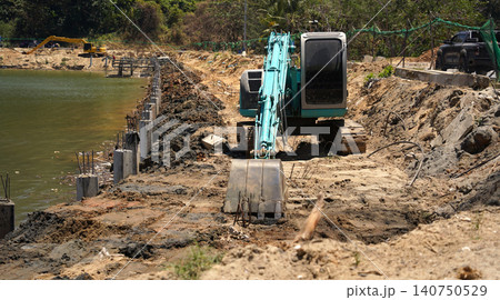 Building process city levee. Excavator dredging pond bank Building process city levee. Excavator dredging pond bank 140750529
