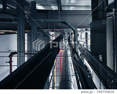 Plant corridor with pipes and valves. View of factory pipeline with lighting and supports Plant corridor with pipes and valves. View of factory pipeline with lighting and supports 140750628