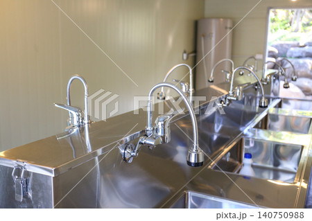 Row of Clean Stainless Steel Sinks and Faucets in a Public Facility Row of Clean Stainless Steel Sinks and Faucets in a Public Facility 140750988