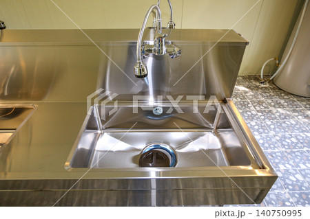 Row of Clean Stainless Steel Sinks and Faucets in a Public Facility 140750995