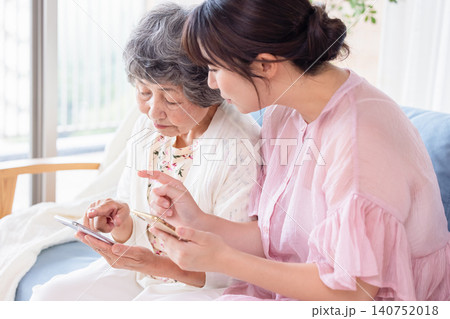 祖母にスマートフォンの使い方を教える孫 祖母にスマートフォンの使い方を教える孫 140752018