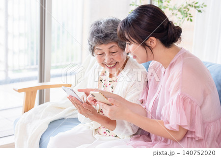 祖母にスマートフォンの使い方を教える孫 140752020