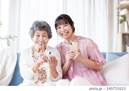 祖母にスマートフォンの使い方を教える孫 祖母にスマートフォンの使い方を教える孫 140752023