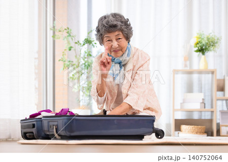 スーツケースに荷物を詰めるシニア女性 スーツケースに荷物を詰めるシニア女性 140752064