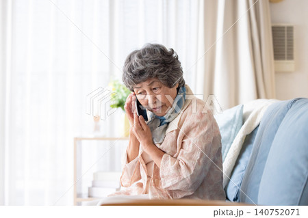 不審な電話に出るシニア女性 140752071
