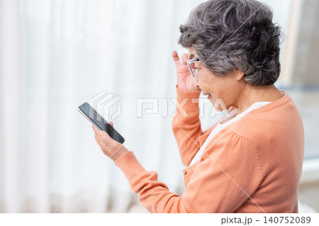 老眼鏡をかけてスマホを操作するシニア女性 老眼鏡をかけてスマホを操作するシニア女性 140752089